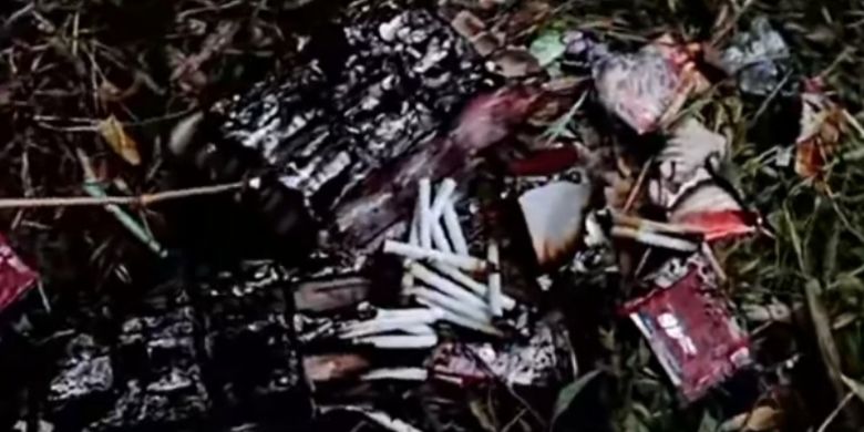 Ratusan batang rokok yang ditemukan dari dalam bus dikeluarkan oleh petugas saat proses pemadaman api, Minggu (1/6/2025). 