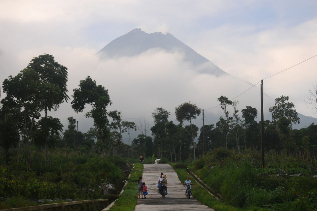 Sejumlah warga melintasi jalan pedesaan Tlogomulyo, Tlogolele, Selo, Boyolali, Jawa Tengah, Kamis (24/5). Berdasarkan data Pos Pengamatan Gunung Merapi Jrakah, kembali terjadi letusan freatik Gunung Merapi Kamis (24/5) pada pukul 02.56 WIB dan 10.48 WIB, hingga diumumkan status waspada dan warga dihimbau tetap tenang. ANTARA FOTO/Aloysius Jarot Nugroho/foc/18.