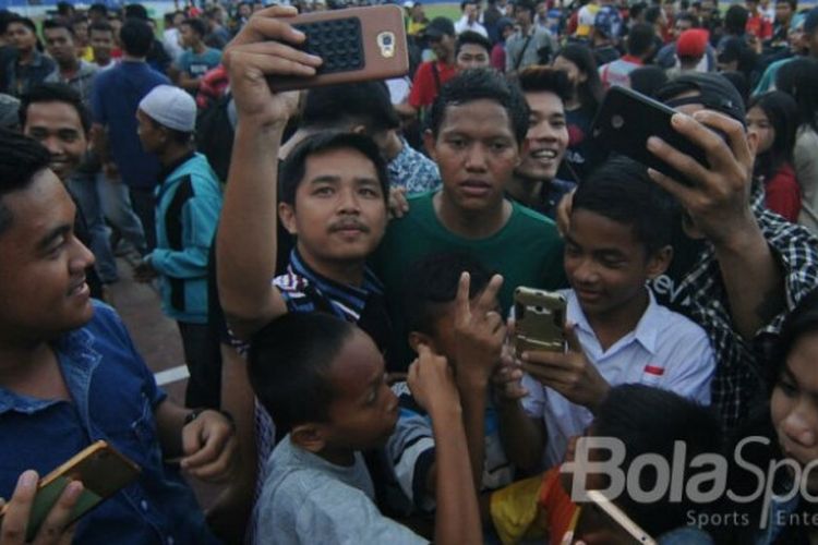 Pemain Sriwijaya FC Palembang, Adam Alis (baju hijau), mendapat sambutan dari pendukung setia pada latihan perdana ,Senin (4/12/2017) di stadion Bumi Sriwijaya Palembang.