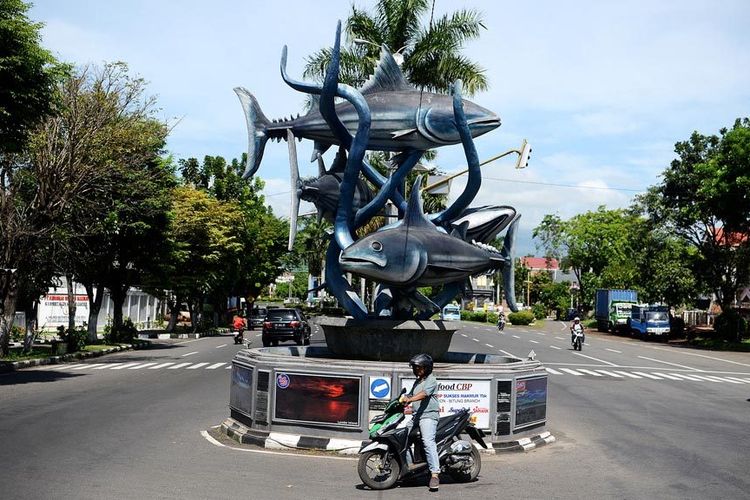 Warga melintas di dekat Tugu Cakalang yang merupakan salah satu ikon di Kota Bitung, Sulawesi Utara. Kota Bitung juga dikenal sengan julukan sebagai Kota Cakalang.