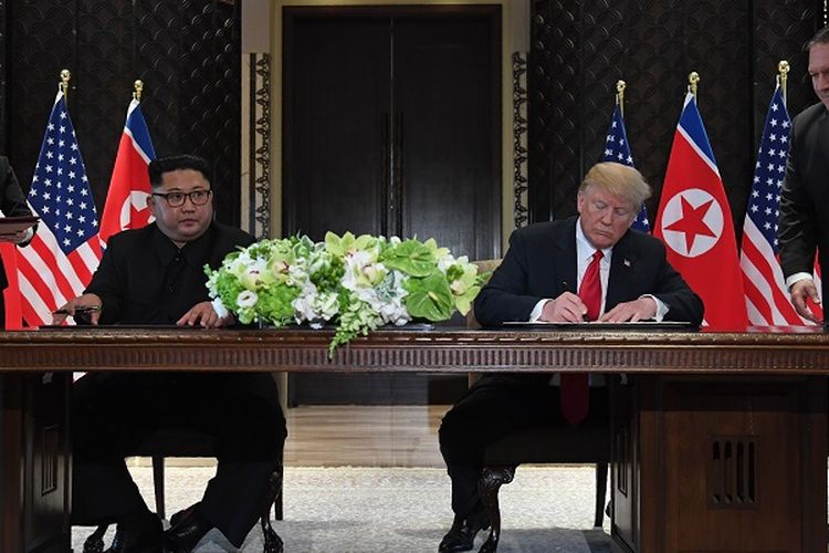 Presiden AS Donald Trump dan pemimpin Korea Utara Kim Jong Un menandatangani kesepakatan usai melakukan pertemuan di Hotel Capella, Singapura, Selasa (12/6/2018). Penandatanganan ini disaksikan Menlu AS Mike Pompeo dan adik Kim Jong Un, Kim Yo Jong.
