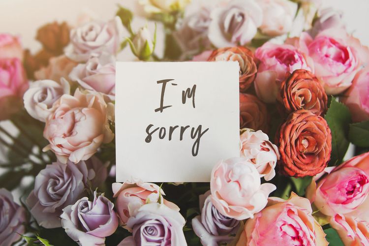 Ilustrasi buket bunga dengan kartu ucapan permintaan maaf. 