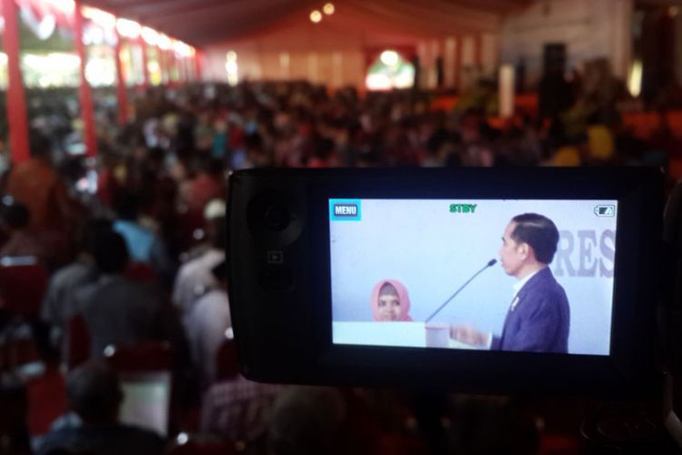 Presiden Joko Widodo bersama Titin Destiani dalam acara pembagian sertifikat tanah di Lapangan Brawijaya, Rampal, Kota Malang, Rabu (24/5/2017)