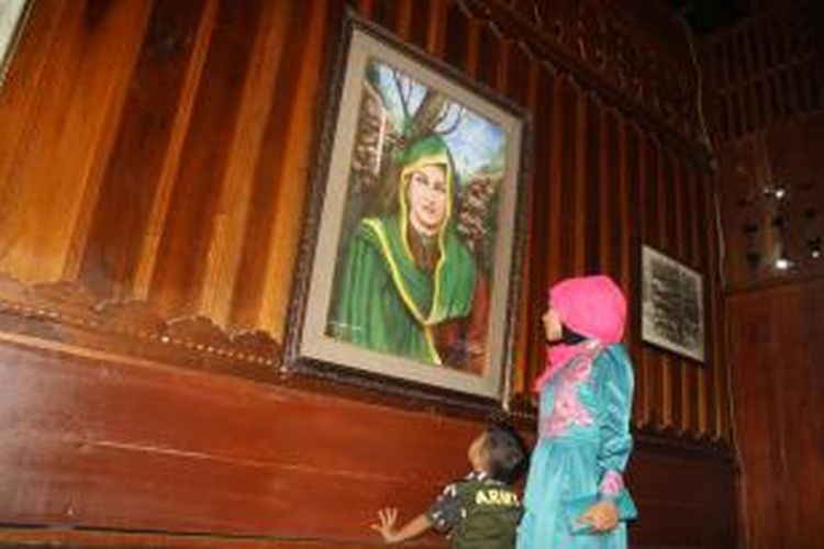 Pengunjung melihat lukisan Cut Meutia di rumah pahlawan nasional Cut Meutia di Desa Beringen Pirak, Kecamatan Matangkuli, Aceh Utara, Kamis (24/9/2015). Rumah ini ramai dikunjungi saat hari raya seperti Idul Adha tahun ini.