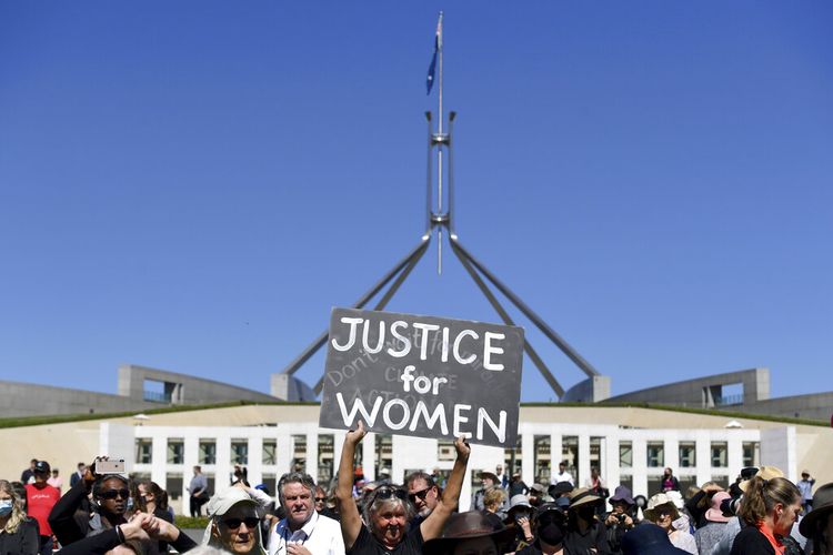 Seorang pengunjuk rasa memegang plakat saat Women's March 4 Justice di Canberra, Australia, Senin, 15 Maret 2021.
