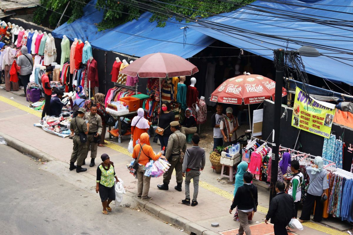 Sejumlah petugas Satpol PP berjaga di atas trotoar yang dipenuhi Pedagang Kaki Lima (PKL) di Tanah Abang, Jakarta, Rabu (18/10/2017). Meskipun sudah ditertibkan, para PKL tersebut masih saja berjualan di atas trotoar dengan alasan harga sewa toko yang sangat mahal.