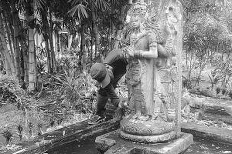 Seorang pegawai PT Perkebunan Nusantara (PN) XII tengah membersihkan arca Siwa berumur ratusan tahun yang dipindahkan ke kantor PT PN XII Ngrangkah Pawon, Kediri, Jawa Timur, Minggu (19/1/2014). 
