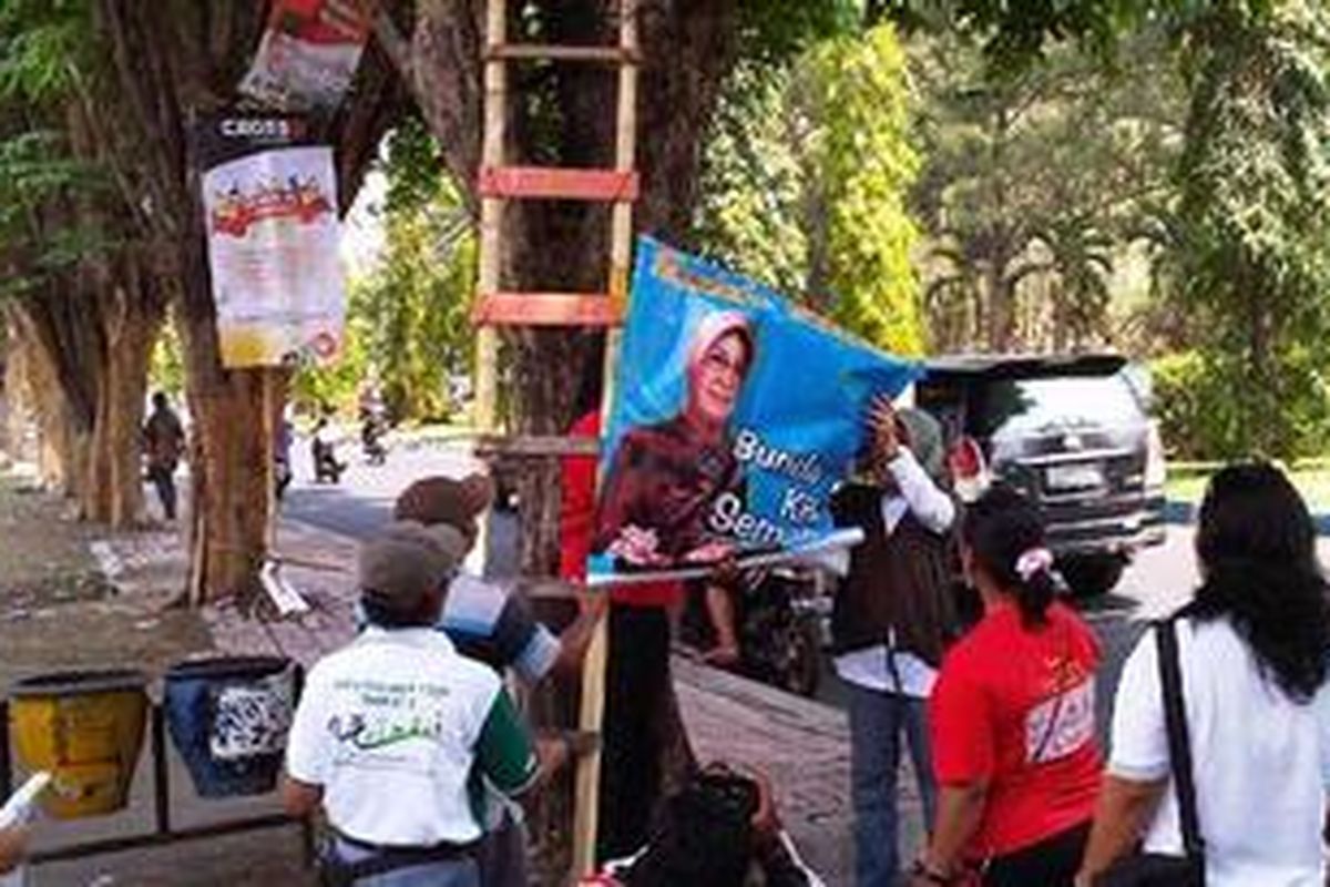 Heri Pudji Utami lepas poster bergambar dirinya yang dipaku di atas pohon. Bahkan ia nekat naik pohon demi menyelamatkan pohon.Minggu (14/10/2012)