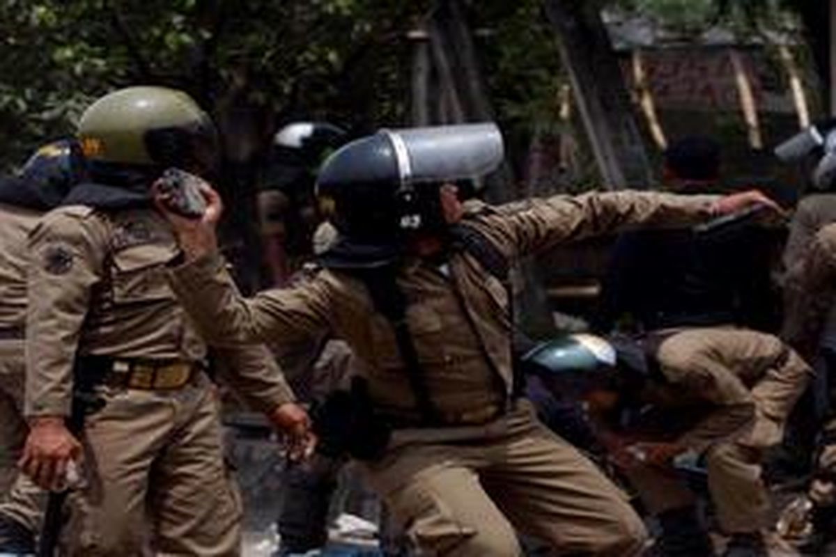 Aksi saling lempar batu saat bentrok antara warga dengan satpol pp dalam upaya pembongkaran kompleks makam Mbah Priuk di Tanjung Priok, Jakarta Utara, Rabu (14/4/2010). Bentrokan ini mengakibatkan sedikitnya 15 orang terluka dan belasan kendaraan roda dua dan empat dibakar massa. 