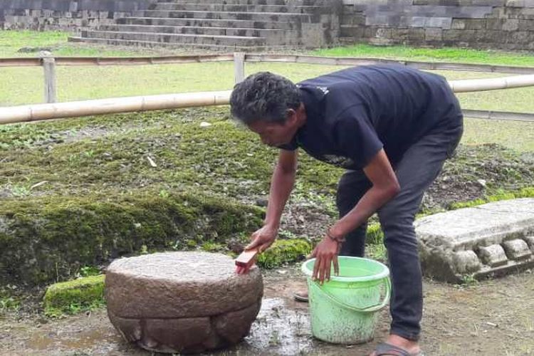 Petugas BPCB membersihkan batu bermotif padma dari tanah yang menempel di batu yang ditemukan saat studi teknis pelurusan sungai di kawasan Situs Liyangan, Desa Purbosari, Kecamatan Ngadirejo, Kabupaten Temanggung, jawa Tengah. 