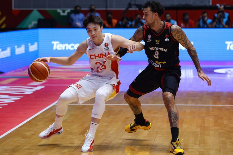 Pemain timnas basket China, Mingxuan Hu mencoba melewati pemain timnas basket Indonesia, Brandon Jawato pada laga playoff FIBA Asia Cup 2022 di Istora Senayan, Jakarta, Senin (18/7/2022). Indonesia kalah dengan skor 58-108.