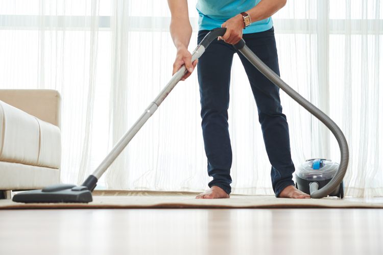 Ilustrasi menggunakan vacuum cleaner untuk membersihkan karpet. 