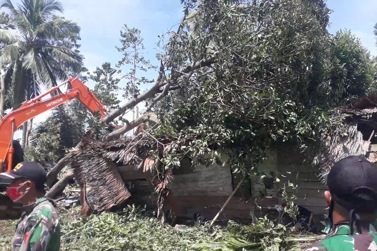 TNI Kodim 1403 Sawerigading menurunkan alat berat dan mesin pemotong kayu untuk membersihkan rumah yang tertimpa pohon akibat puting beliung di Desa salu pao, Kecamatan Lamasi Timur, Selasa (16/02/2021)