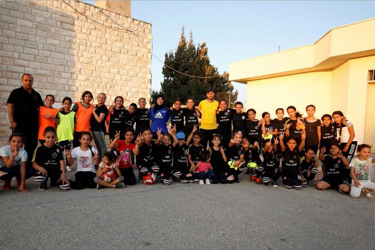 Puluhan gadis muda Palestina yang berlatih sepak bola di lapangan Desa Deir Jarir, di luar Ramallah, Tepi Barat. Mereka berlatih di bawah pengawasan ketat pelatih Rajaa Hamdan.  