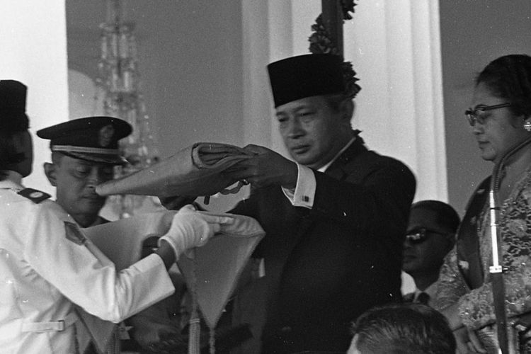 Presiden Soeharto didampingi Ibu Tien tengah menyerahkan Bendera kepada Paskibraka pada Upacara Peringatan Hari Kemerdekaan tahun 1971. - Sejarah Paskibraka
