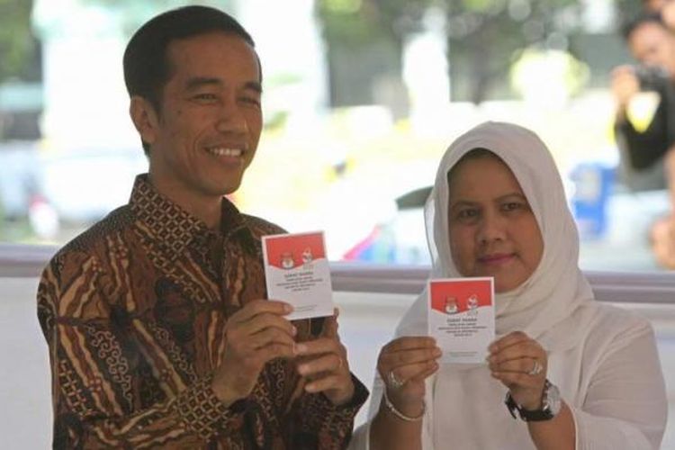 Calon presiden Joko Widodo bersama istrinya Iriana, menunjukkan surat suara usai mencoblos dalam Pilpres 2014 di TPS 18 Menteng, Jakarta Pusat, Rabu (9/7/2014).