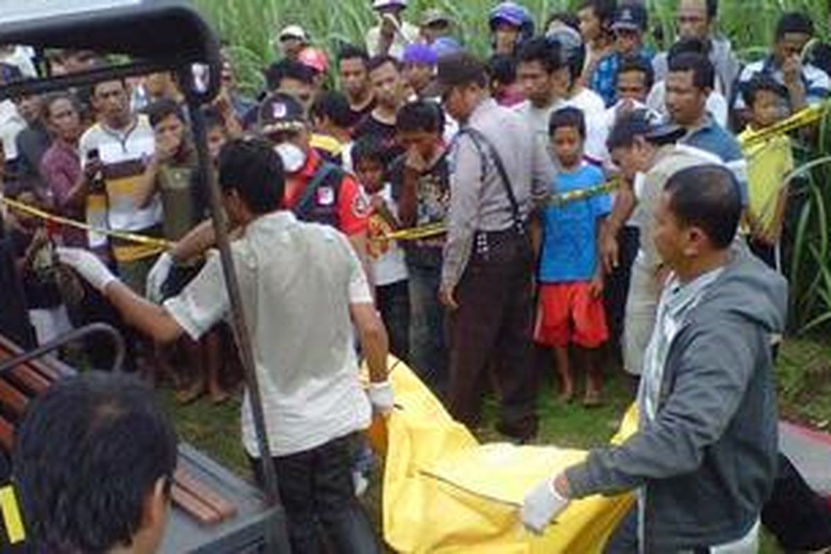 Petugas Identifikasi Polres Kediri dibantu warga mengangkat jenazah Suparmi ke mobil patroli untuk kemudian dibawa ke RS Bhayangkara, Selasa (1/1/2012). 