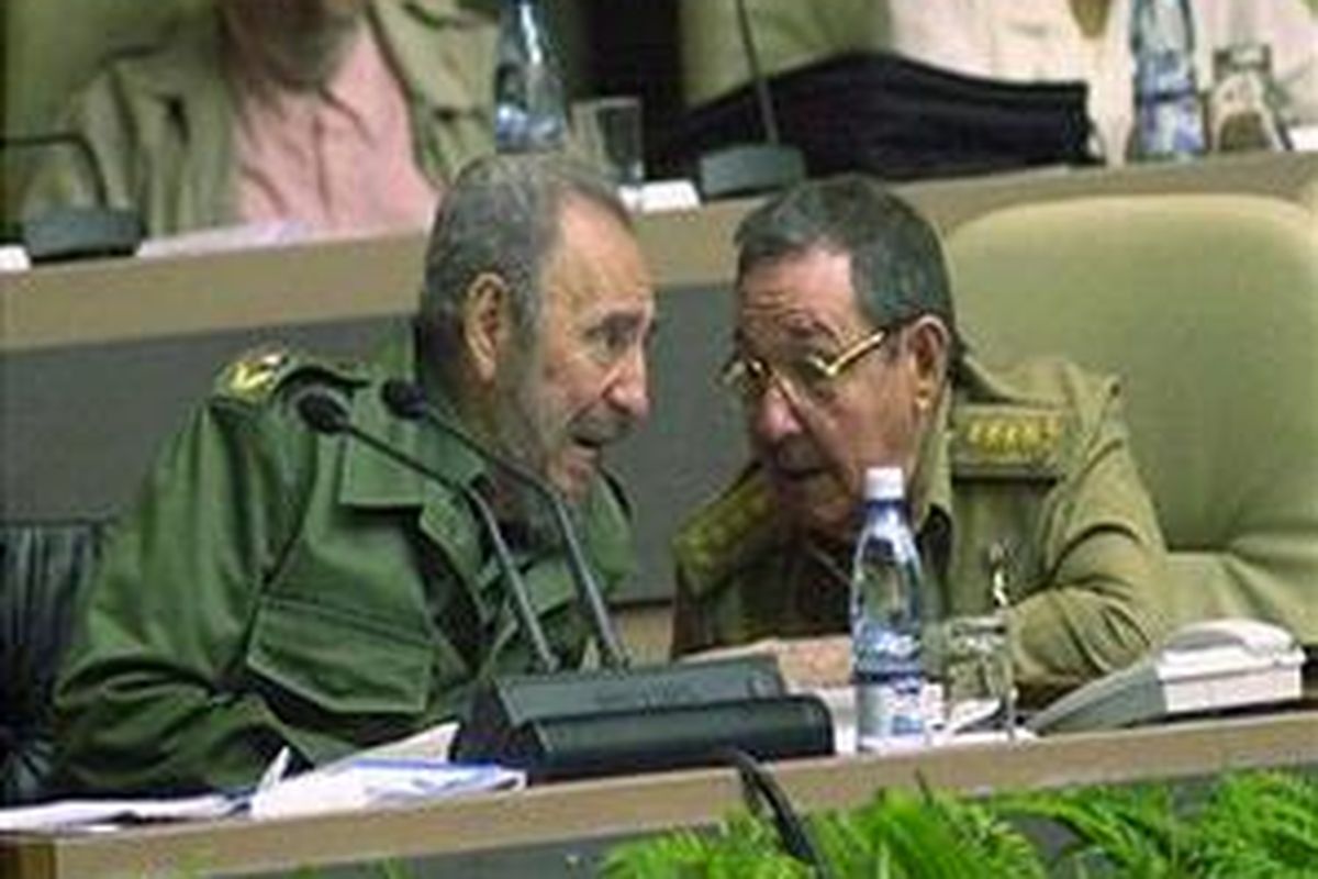 Fidel Castro (kiri) berbicara ke adiknya Raul Castro (kanan) selama rapat parlemen Kuba di Havana, Kuba, 23 Desember 2004.  