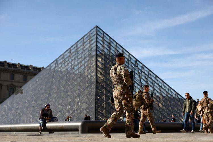 Tentara Sentinelle Perancis berpatroli di piramida kaca Museum Louvre pada 30 Oktober 2025, setelah terjadi pencurian besar-besaran yang bernilai Rp 1,7 triliun.