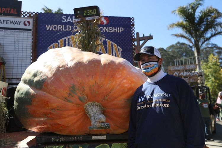 Travis Gienger berdiri di samping labu seberat 1,246 ton saat Kejuaraan Dunia Safeway Pumpkin Weigh-Off pada 12 Oktober 2020 di Half Moon Bay, California.  