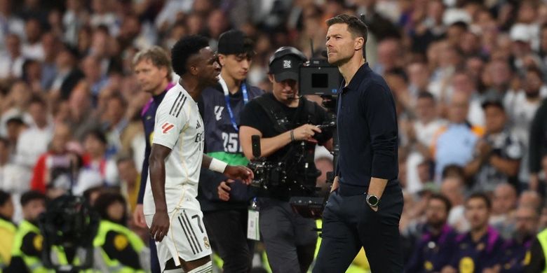 Vinicius Junior berjalan melewati pelatihnya Xabi Alonso saat dia diganti dalam pertandingan sepak bola Liga Spanyol antara Real Madrid CF vs FC Barcelona di Stadion Santiago Bernabeu di Madrid pada 26 Oktober 2025. (Foto oleh Oscar DEL POZO / AFP)
