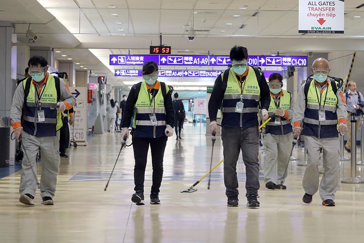 Pekerja bermasker melakukan kegiatan desinfeksi di area Bandara Internasional Taoyuan, Taiwan, Rabu (22/1/2020), menyusul temuan warga diduga terinfeksi virus corona di negara itu. Hingga saat ini, sudah 12 negara di berbagai belahan Bumi yang positif mengumumkan terdampak virus corona yang dilaporkan sudah menjangkiti 1.300 orang dan membunuh 41 orang di China.