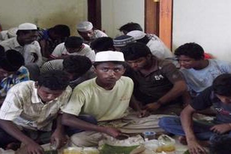 Sebanyak 74 warga etnis Rohingnya, Myanmar menikmati nasi bungkus yang disediakan oleh Dinas Sosial Aceh Besar, saat ditampung di Gedung Balai Latihan Kerja Pelabuhan Malahayati, Aceh Besar, Senin (8/4/2013). Para pengungsi tersebut ditemukan terdampar di Pulo Aceh, Minggu (7/4/2013).

