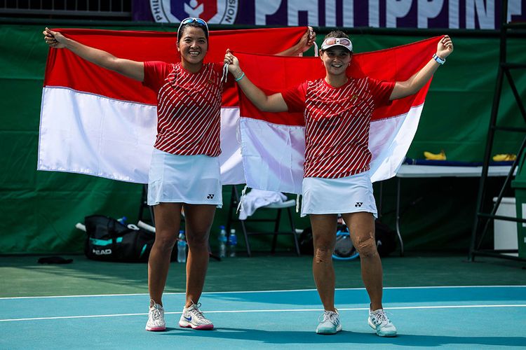 Pasangan ganda putri timnas tenis Indonesia, Beatrice Gumulya (kanan) dan Jessy Rompies mengekspresikan kemenangan dengan mengangkat bendera Merah Putih usai memenangkan babak Final ganda putri saat melawan pasangan dari Thailand, Peangtarn Plipuech/Tamarine Tanasugarn di Rizal Memorial Tennis Centre, Manila, Filipina, Sabtu (7/12/2019). Beatrice/Jessy meraih medali emas ganda putri pada SEA Games 2019, dengan mengalahkan unggulan kedua dari Thailand, Peangtarn Plipuech/Tamarine Tanasugarn, 6-3, 6-3.