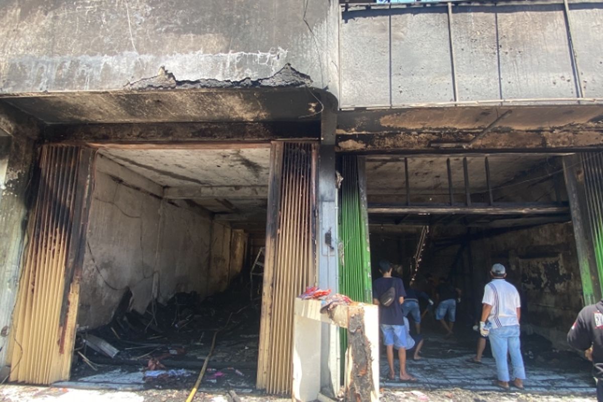 Pedagang Pasar Krian Lama mengais barangnya yang terbakar, Selasa (20/8/2024).