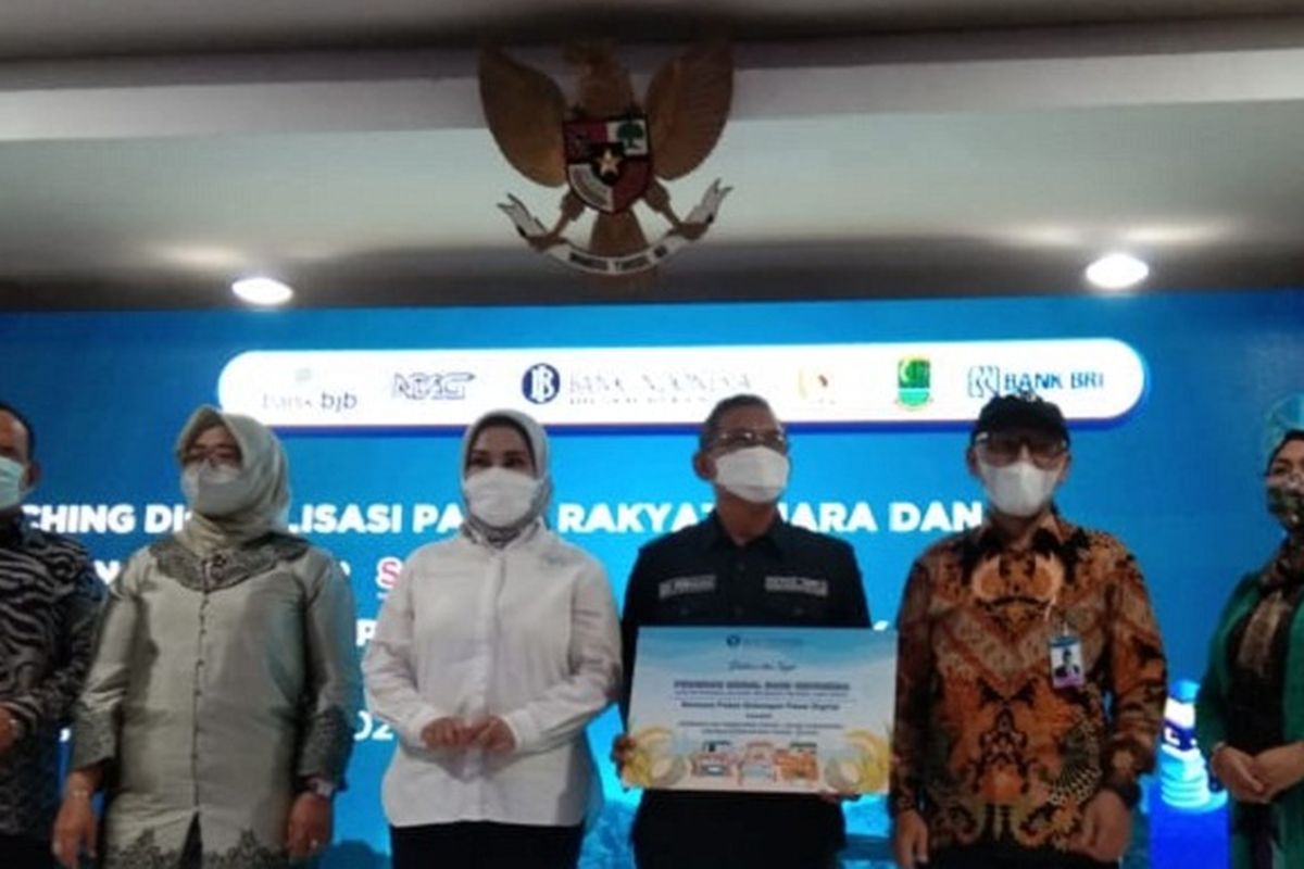 Kepala Perwakilan BI Jawa Barat Herawanto didampingi Anggota DPR RI Vera Febyanthy memnyerahkan bantuan sepaket dukungan digitalisasi pasar kepada Ketua Ikatan Pedagang Pasar Johar Edi Permana , Kamis (16/12/2021).