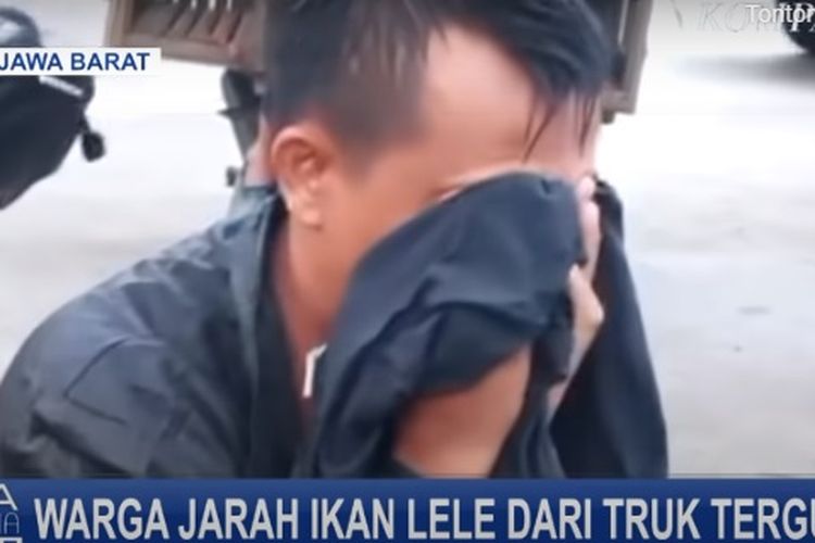 Edi, pengemudi truk lele hanya bisa menangis di pinggir sawah melihat lele yang dibawanya dijarah oleh warga.