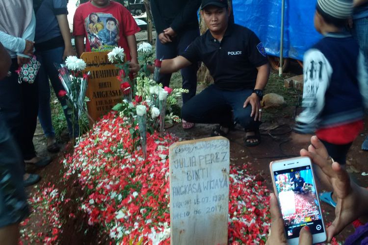 Para warga sekitar datang ke makam Julia Perez di TPU Pondok Ranggon, Jakarta Timur, pada Minggu (11/6/2017). Ada yang nyekar, ada pula yang sekadar berfoto di pusara Jupe.