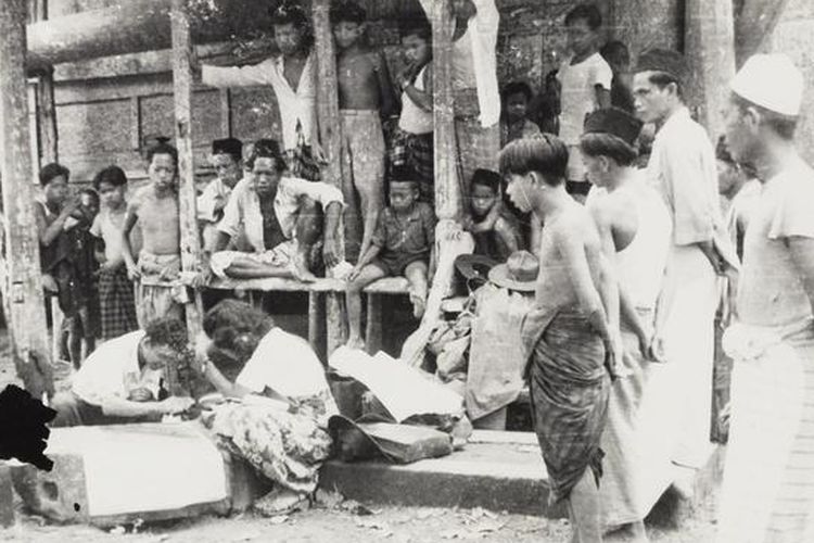 Pribumi Bangka sedang memperhatikan arkeolog bekerja