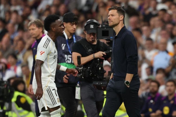 Vinicius Junior berjalan melewati pelatihnya Xabi Alonso saat dia diganti dalam pertandingan sepak bola Liga Spanyol antara Real Madrid CF vs FC Barcelona di Stadion Santiago Bernabeu di Madrid pada 26 Oktober 2025. (Foto oleh Oscar DEL POZO / AFP)