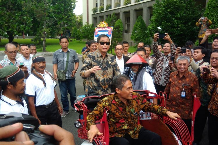 Menteri ESDM Ignatius Jonan (Kacamata Hitam) Mengendarai Becak Listrik dengan Penumpang Rektor UGM Panut Mulyono