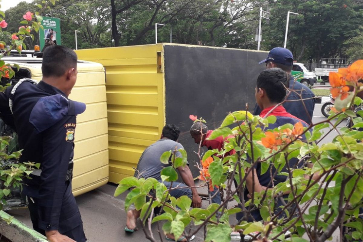 Petugas berupaya mengevakuasi mobil boks yang terbalik di Jalan Benyamin Sueb, Jakarta Utara, Selasa (23/10/2018).