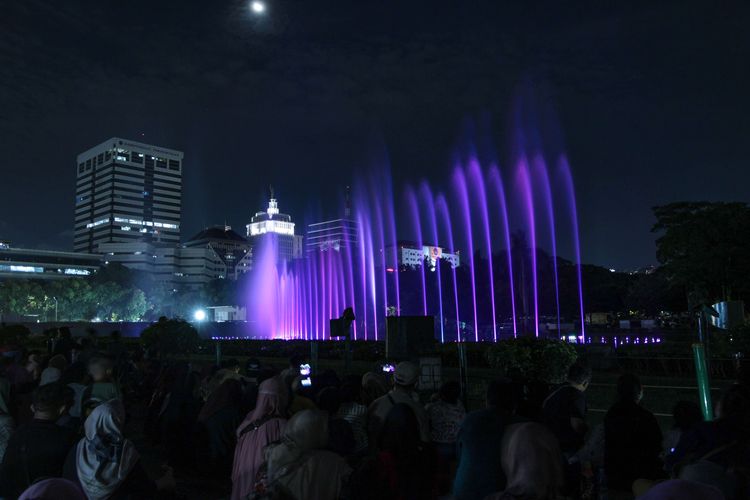 Atraksi air mancur menari di Monumen Nasional, Jakarta, Selasa (25/4/2023) malam. Selain air mancur menari, pengunjung juga bisa menyaksikan pertunjukan video mapping di dinding tugu Monumen Nasional untuk mengisi libur Learan 2023.