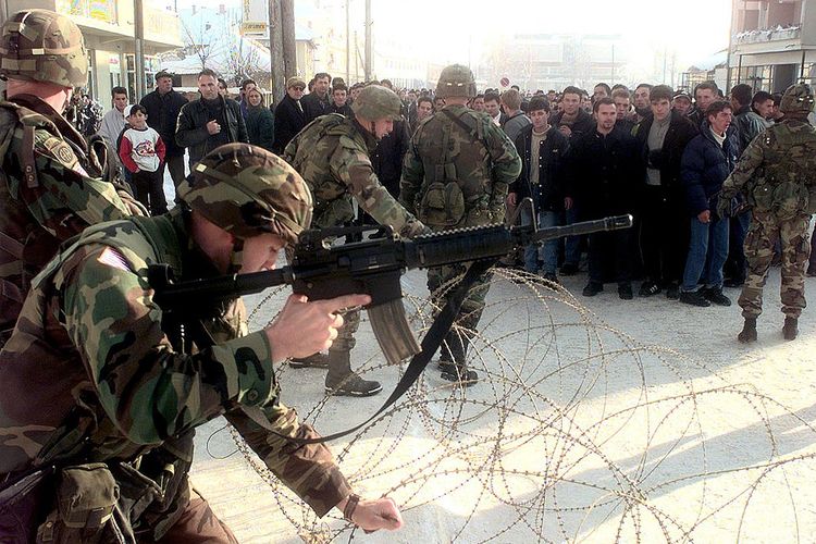 Tentara AS mengendalikan penduduk Albania di Kosovo pada 9 Januari 2000.