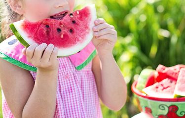 Seorang anak yang sedang memakan semangka