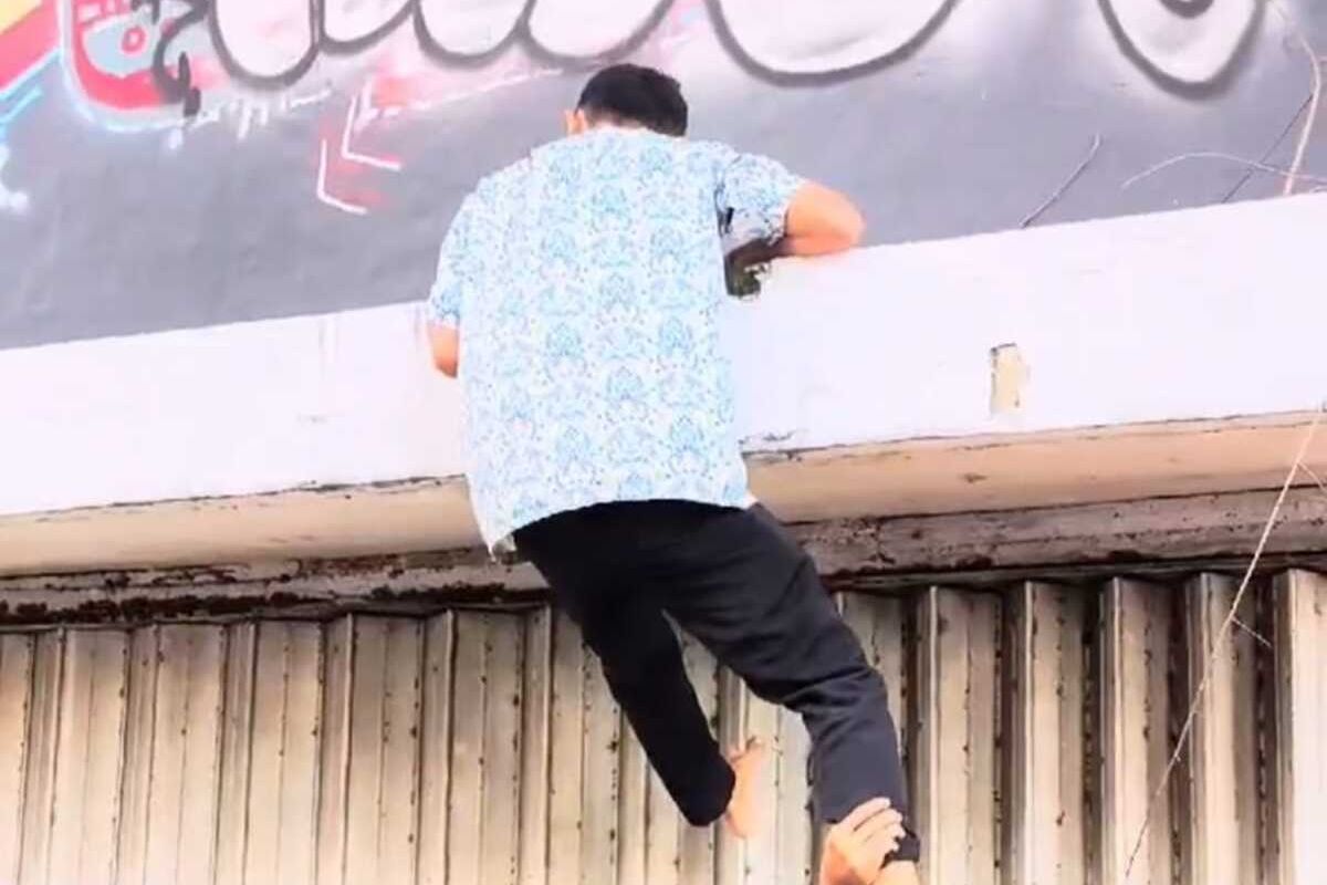 Warga Surabaya memanjat balkon bangunan di Jalan Tunjungan untuk berburu Koin Jagat.