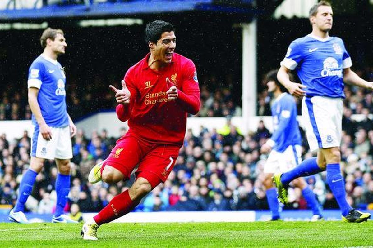 Pemain Liverpool, Luis Suarez (tengah), bergembira setelah mencetak gol ke gawang Everton pada pertandingan Liga Primer di Stadion Goodison Park, Liverpool, Inggris, Minggu (28/10).
