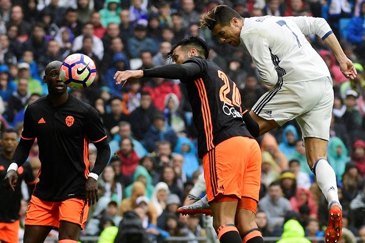 Penyerang Real Madrid, Cristiano Ronaldo (kanan) mencetak gol dengan melepaskan tandukan keras ke gawang Valencia di Stadion Santiago Bernabeu pada 29 April 2017.  