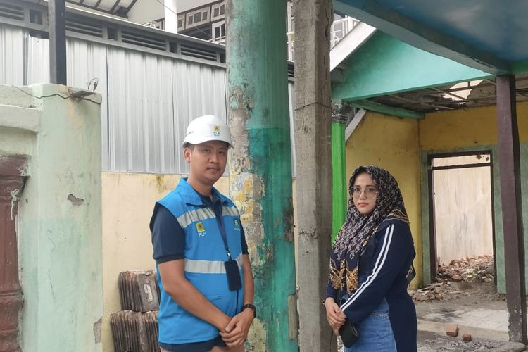 Pemilik rumah ada tiang listrik di terasnya, Siti Kotijah (kanan) bersama karyawan PLN