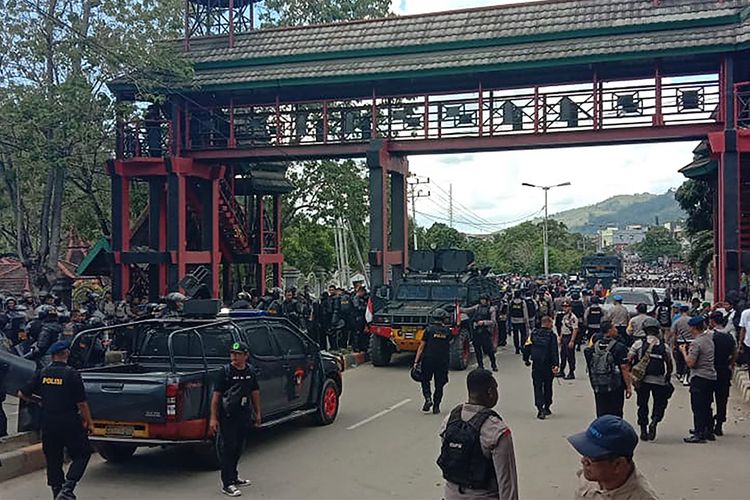 Sejumlah personel polisi berjaga di sebuah universitas di Jayapura, Papua, menyusul kerusuhan yang terjadi, Senin (23/9/2019) siang. Gubernur Papua Lukas Enembe menyebut terdapat korban jiwa dan luka-luka dari kerusuhan yang masih ditelusuri penyebabnya tersebut.
