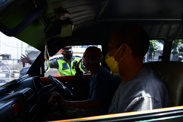 Petugas terlihat melakukan penindakan kepada masyarakat yang tidak menggunakan masker saat PPKM Darurat di Jalan Merdeka, Kota Bandung.