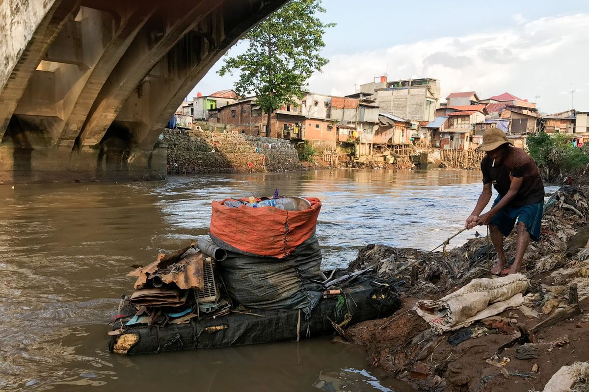 Suparno (69) atau dikenal dengan sebutan Pak Kentir tengah melabuhkan pelampung yang berbentuk seperti perahu di pinggir Sungai Ciliwung tepatnya di bawah jembatan bersejarah di kawasan Manggarai, Tebet, Jakarta Selatan pada Jumat (12/3/2021) sore. Pak Kentir sehari-hari mencari sampah dan barang rongsok untuk dijual demi memenuhi kebutuhan sehari-hari.