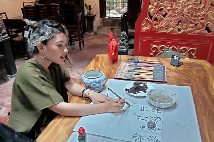 Salah satu tim Kompas.com mencoba belajar dasar kaligrafi Tionghoa di Museum Benteng Heritage.