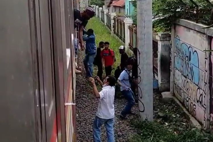 Penumpang KRL tujuan Rangkasbitung turun dari rangkaian kereta setelah KRL tersebut berhenti lebih dari satu jam, penumpang kemudian jalan kaki ke stasiun Sabtu (23/7/2022).