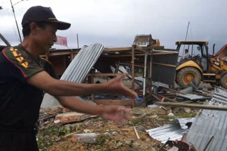 Petugas Satpol PP Kota Gunungsitoli membersihkan puing-puing bangunan dan alat berat eskavator terus merobohkan seluruh bangunan di kawasan pinggir pantai di Kota Gunungsitoli, Sumatera Utara.