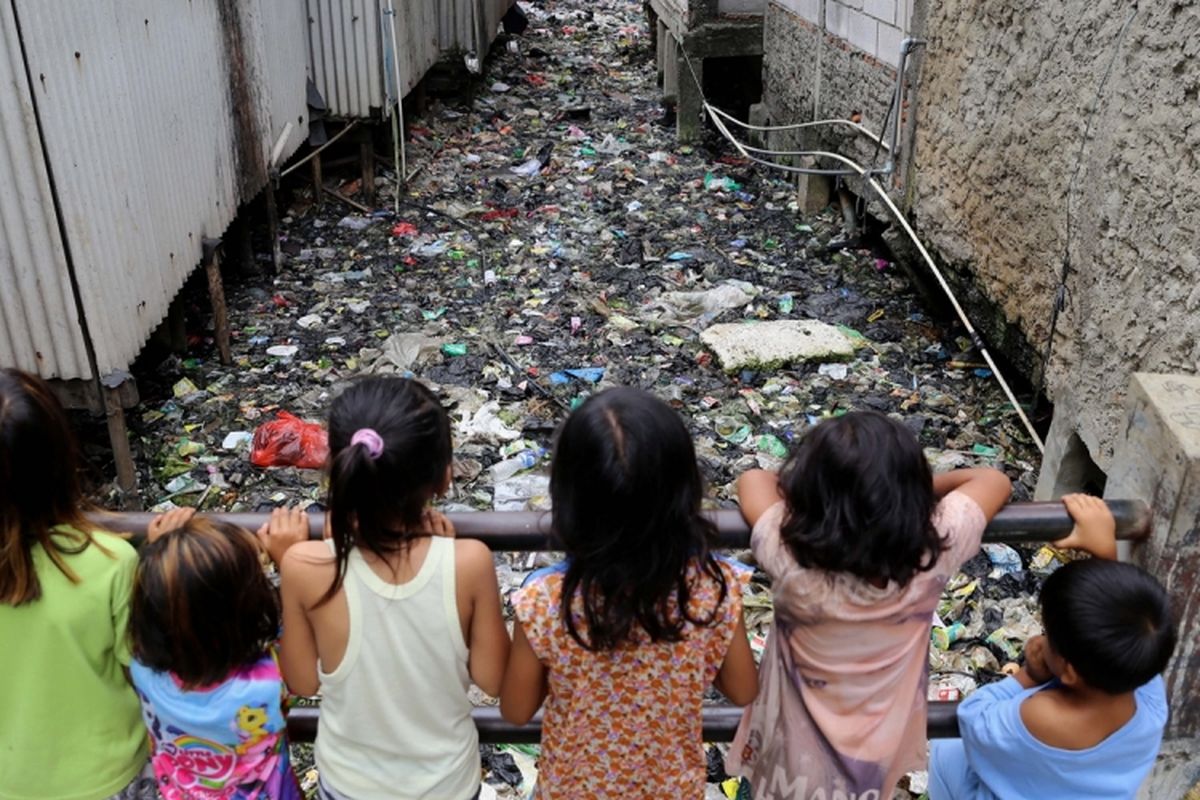Sejumlah anak bermain di Kali Gendong, Waduk Pluit, Penjaringan, Jakarta Utara, Selasa (14/3/2017). Kurangnya kesadaran masyarakat membuang sampah sembarangan mengakibatkan sampah plastik dari rumah tangga nyaris menyerupai daratan tersebut menumpuk di sepanjang Kali Gendong.